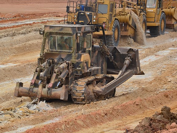 A Komatsu D155A dozer pre-rips the borrow pit. Love the camo paint job.