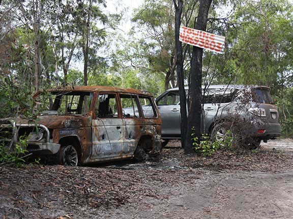 Nissan Patrol 4x4 with burnt-out vehicle