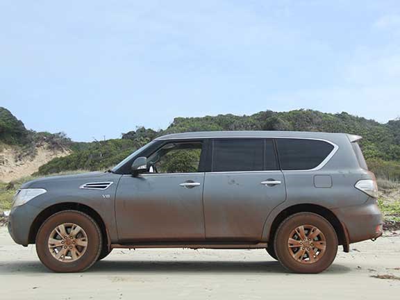 Side view of mud-covered Nissan Patrol 4x4
