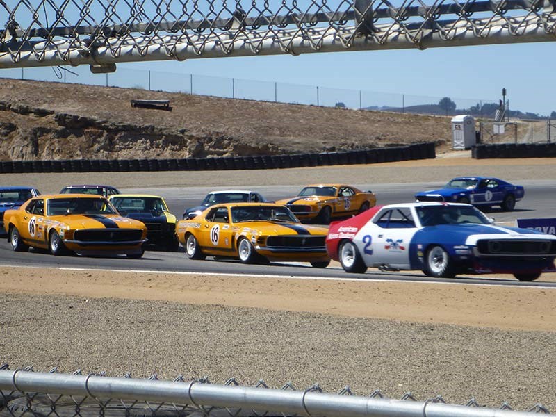 AMC leads a pair of Grabber Orange Boss Mustangs at Laguna Seca