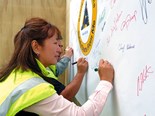 Logistics manager Marifé Gregory places her artistic signature on the Sika Safety banner